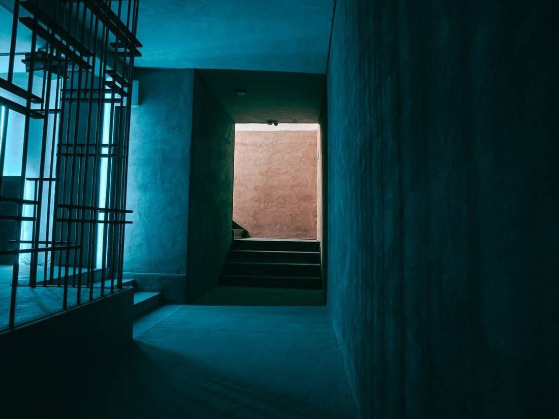 Escalera de acceso de DUNA CLUB, con un muro en tono terracota al fondo.